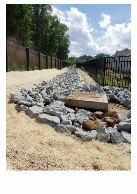 Riprap stone-lined drainage swale in Charlotte NC