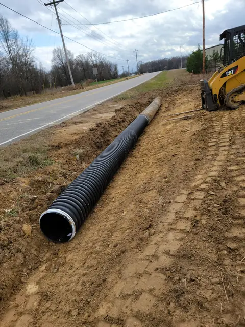 Drainage pipe installation with skid steer in Charlotte NC
