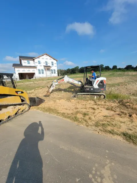 Skid steer y mini excavadora trabajando en un lote en Charlotte NC